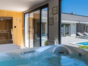 a hot tub in the backyard of a house at Holiday Home Villa Romantica by Interhome in Nedeščina