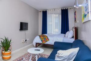 a bedroom with a bed and a blue couch at Faraja Apartment at Coral Bells in Nairobi