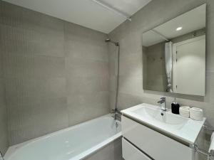a bathroom with a sink and a tub and a mirror at San Fermin Centro II in Pamplona
