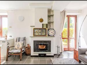 a living room with a fireplace and a clock on the wall at Apartment La Sostra by Interhome in Domaso