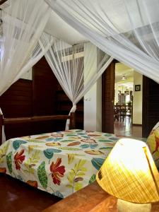 a bedroom with a bed with a floral comforter at Appartement ATIALA in Hell-Ville