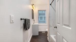 a white bathroom with a toilet and a sink at Walk to Niagara Falls! 12 Bedrooms! in Niagara Falls +50 photos