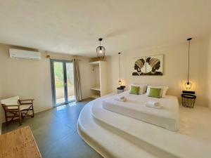 a large white bedroom with a large white bed at Hidden Eden Residences - Private Pools in Plaka