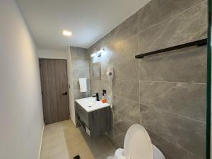 a bathroom with a white toilet and a sink at Casa Martina Manga Cartagena in Cartagena de Indias