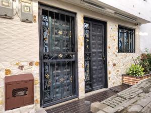 une maison avec des portes noires et une télévision en façade dans l'établissement Casa Hévenie, Amplia, familiar, cómoda y bien ubicada, à El Poblado