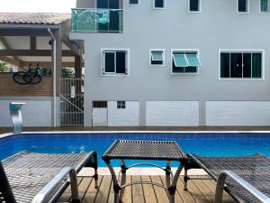 two chairs and a table next to a swimming pool at Pousada Altas Natureza in Florianópolis