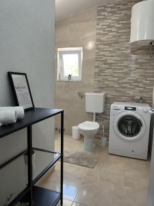 een badkamer met wasmachine en toilet bij Villa Villa Nadin in Nadin