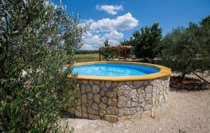 a small pool in a stone wall with a gazebo at House Mala kuca in Oklaj