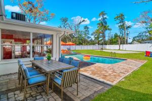 a patio with a table and chairs next to a swimming pool at Heated Pool Pickleball Mini Golf — Sleeps 20 in Clearwater