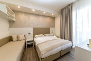 a hotel room with a bed and a window at Hotel Touring in Lido di Jesolo