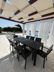 een zwarte eettafel en stoelen op een patio bij Villa Villa Nadin in Nadin