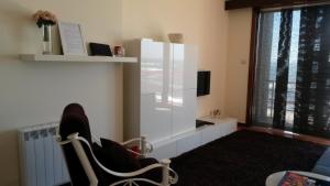 a living room with a white cabinet and a chair at Apartamento na Praia in Póvoa de Varzim