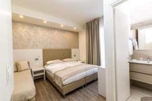 a hotel room with a bed and a sink at Hotel Touring in Lido di Jesolo