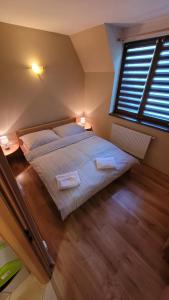 塔查斯卡-鲁穆尼卡Apartmány u tatranky的一间卧室，配有一张大床和一扇窗户。