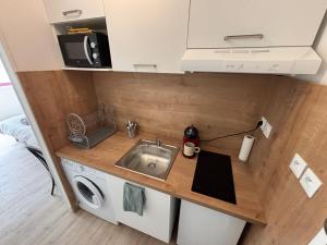 a kitchen with a sink and a microwave at Le Studio du Marechal in Niort +9 photos