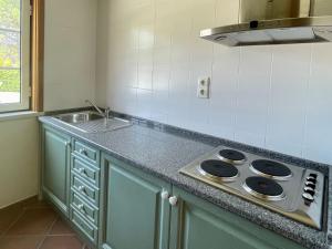 a kitchen counter with a sink and a stove at Holiday Home Casa dos Loendros by Interhome in Alcácer do Sal
