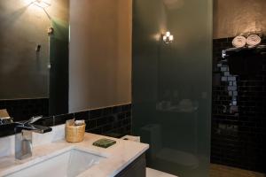 y baño con lavabo y ducha con espejo. en Bungalows Demetria, en Guadalajara