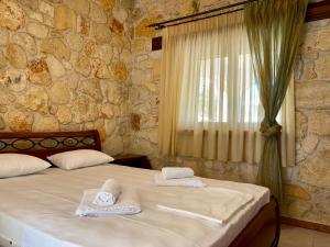a bedroom with two beds and a stone wall at Kappa Domus in Siviri