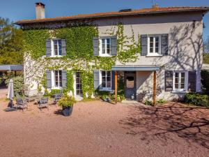 a house with ivy on the side of it at Domaine d'AROMM - Chambres d'hotes & gites - Piscine, Jacuzzi, Etangs & Animaux - Au calme in Ouches