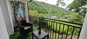 a balcony with a chair and a table and a view at Apartman D&A in Brekovica
