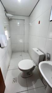 a white bathroom with a toilet and a sink at Hotel Veneza in Brasília +17 photos