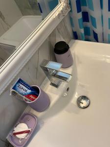 a bathroom with a sink with various items on it at CX Family Apartment in Bucharest +11 photos