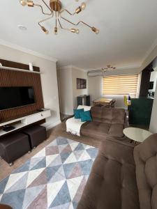 a living room with a couch and a flat screen tv at Air-conditioned apartment - Privileged Location and Vacancy! in Florianópolis
