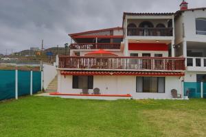 a large house with a balcony and a yard at Encantó del Mar - Beachfront house in Tijuana