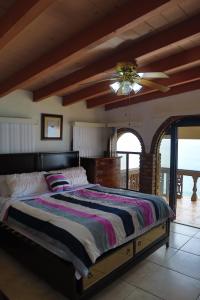 a bedroom with a large bed and a ceiling fan at Encantó del Mar - Beachfront house in Tijuana