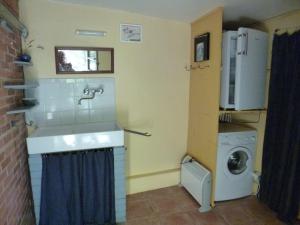 a small kitchen with a sink and a washing machine at Roulotte in Aubres