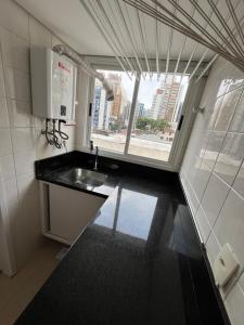 a small kitchen with a sink and a window at Air-conditioned apartment - Privileged Location and Vacancy! in Florianópolis +65 photos