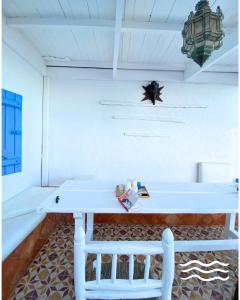 a white table with a chair in a room at Afoulki Home in Taghazout