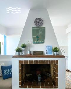 a brick fireplace with a clock on top of it at Afoulki Home in Taghazout +26 photos