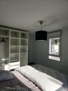 une chambre avec un grand lit et une fenêtre dans l'établissement Cocon Vaulx Village LDLC Groupama Eurexpo, à Vaulx-en-Velin