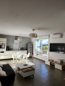 un salon avec un canapé et une table et une cuisine dans l'établissement Cocon Vaulx Village LDLC Groupama Eurexpo, à Vaulx-en-Velin 13 autres photos