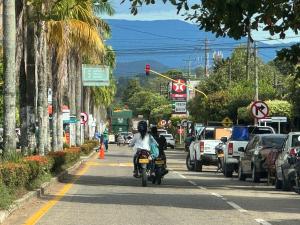 a person riding a motorcycle down a street with a traffic light at Apartamentos amoblados de 1, 2 y 3 dormitorios in Nueva Ola