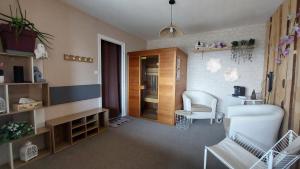 ein Wohnzimmer mit 2 Stühlen, einem Tisch und einem Zimmer in der Unterkunft L'Écrin du Poten'Ciel in Allègre