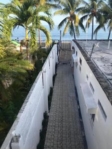 eine weiße Wand mit Bänken am Strand in der Unterkunft Los Chitos in Los Ayala