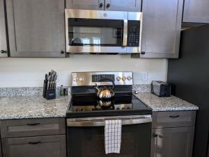 a kitchen with a stove and a microwave at Acadia Sunset Fishing Cabin #5 family beach firepit in Sullivan