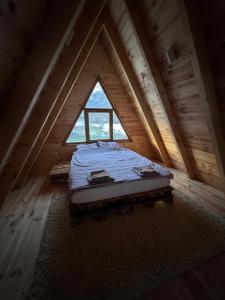 a bed in a room with a large window at Balic Inn in Gusinje