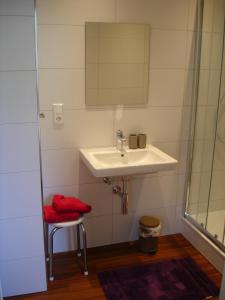 ein Badezimmer mit einem Waschbecken und einem roten Stuhl in der Unterkunft Haus Mosella in Cochem