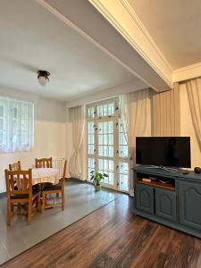 a living room with a television and a table and chairs at Pine Peak in Predeal