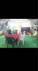 a table and two chairs and a tent at Caravana acogedora con piscina "Amantes de la naturaleza" in Almonte