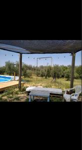 a pavilion with a table and chairs and a playground at Caravana acogedora con piscina "Amantes de la naturaleza" in Almonte +41 photos