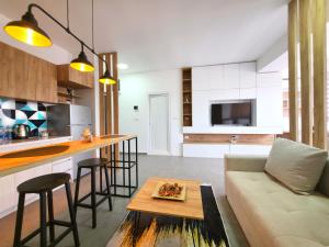 a kitchen and living room with a couch and a table at Urban Serviced Apartments in Skopje