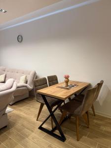 a dining room with a table and a couch at Sky Apartment in Novi Pazar +5 photos