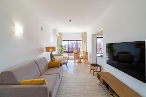 a living room with a couch and a flat screen tv at Sea Breeze in Portimão