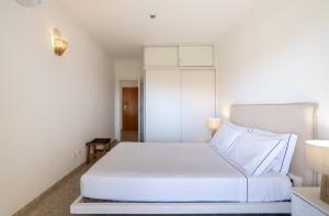 a white bedroom with a large white bed in it at Sea Breeze in Portimão +12 photos