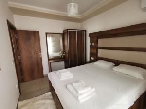 una camera da letto con un letto con due asciugamani sopra di Ulcinj Vibes & Waves Apartment a Ulcinj