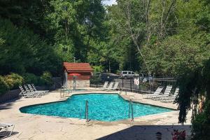 a swimming pool with chairs and a gazebo at Yeti Lodge by Avada Properties in Gatlinburg